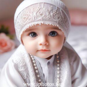 A baby doll in a pink dress and white hat, sitting peacefully on a shelf.