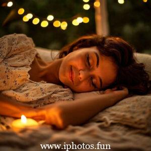 A young girl peacefully sleeping in bed surrounded by flickering candles