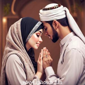 A man and woman in traditional Muslim attire praying in a mosque.