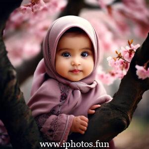 Image of a baby girl wearing a hijab near a tree