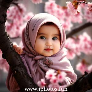 Image of a baby girl wearing a hijab near a tree