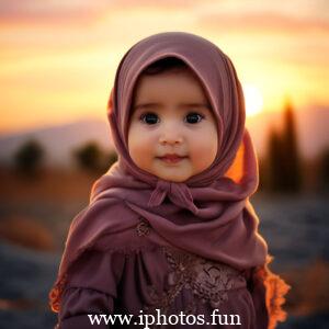 Child in pink hijab standing with sun in background